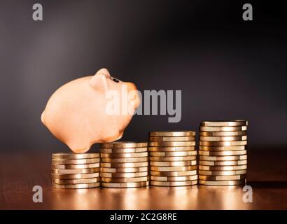 Piggy Bank stehend auf Haufen von Münzen. Stockfoto