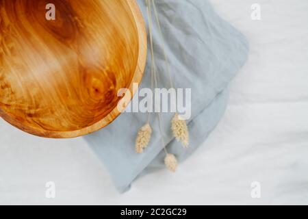 Draufsicht auf eine Holzschale, die auf einer Serviette auf einer weißen Oberfläche steht Stockfoto