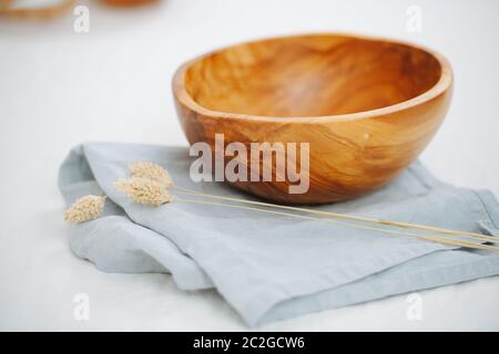 Bild einer Holzschale, die auf einer Serviette auf einer weißen Oberfläche steht Stockfoto