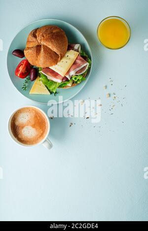 Frühstück serviert mit Kaffee, Saft, Sandwich mit Schinken, Käse, Tomaten und Kopfsalat. Continental leckeren, gesunden Frühstück Tabelle Stockfoto