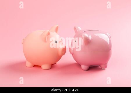 Zwei rosa Sparschweine auf einem rosa Hintergrund. Konzept der Einsparung von Geld oder Einsparungen, Investitionen. Stockfoto