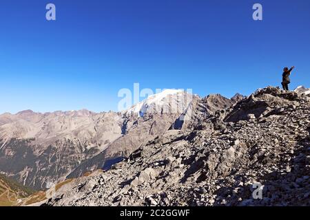 Eine Frau in den Bergen streckt ihre Arme vor Freude aus. Spaß beim Bergsteigen Stockfoto