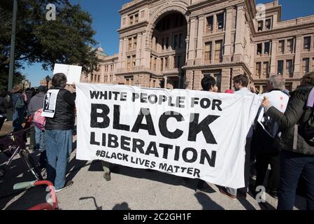 Austin, Texas, USA 18. Januar 2016: Die Teilnehmer der Martin Luther King Day Rallye auf den Südtreppen des Texas Capitol halten ein großes Banner mit dem Titel „Weiße Menschen für die Befreiung der Schwarzen“. ©Bob Daemmrich Stockfoto