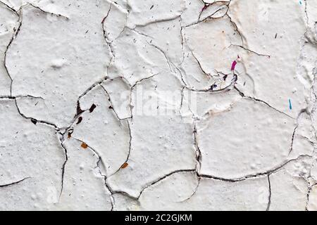 Oberflächenstruktur mit weißer Farbe und Rissen an Betonwand. Für abstrakte Hintergründe. Deutschland Stockfoto