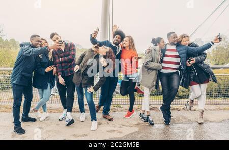 Vielfalt Freunde mit Handys Spaß haben und fotografieren Stockfoto