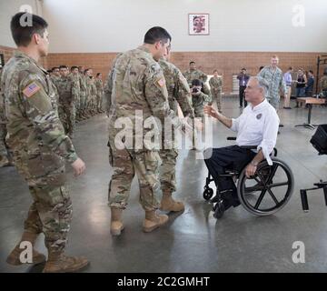 Weslaco, Texas, USA, 12. April 2018: Texas Gov. Greg Abbott begrüßt ein Mitglied der Nationalgarde in einem Waffenlager der Nationalgarde im äußersten Süden von Texas, wo sich die Truppen auf den Einsatz an der Grenze zwischen Texas und Mexiko vorbereiten. Die Soldaten werden bei der Bekämpfung der illegalen Einwanderung an der Südgrenze der Vereinigten Staaten eine unterstützende Rolle bei der Bundes- und Staatspolizei spielen. ©Bob Daemmrich Stockfoto