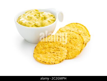 Runde Nacho Chips und Avocado dip. Gelbe Tortilla Chips und Guacamole in Schüssel auf weißem Hintergrund. Stockfoto