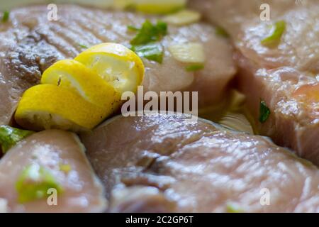 Marinierte Schwertfisch in einer Schüssel mit Zitronensaft, Öl, Knoblauch, Petersilie Stockfoto