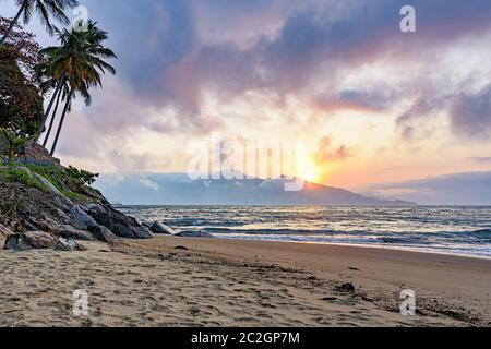 Sonnenuntergang hinter den Bergen an einem Strand auf der Insel Ilhabela Stockfoto