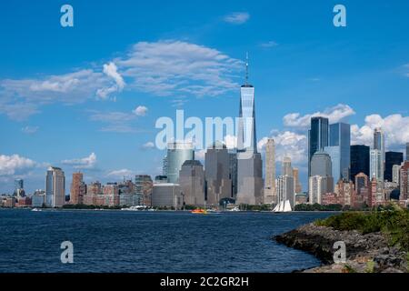 Skyline von Lower Manhattan mit Blick auf Boot und Fähre auf den Hudson River vom Liberty State Park im Spätsommer Stockfoto