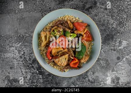 Bulgur Pilaf mit Fleisch und Gemüse. Köstliches warmes Mittagessen auf schwarzem Hintergrund. Östliche Küche. Draufsicht, oben, flach Stockfoto