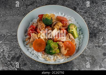 Gegrilltes Huhn, Reis, würzige Kichererbsen, Avocado, Kohl, Pfeffer buddha Schüssel auf dunklem Hintergrund, Draufsicht. Köstliches ausgewogenes Lebensmittelkonzept Stockfoto