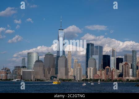 Skyline von Lower Manhattan mit Blick auf Boot und Fähre auf den Hudson River vom Liberty State Park im Spätsommer Stockfoto