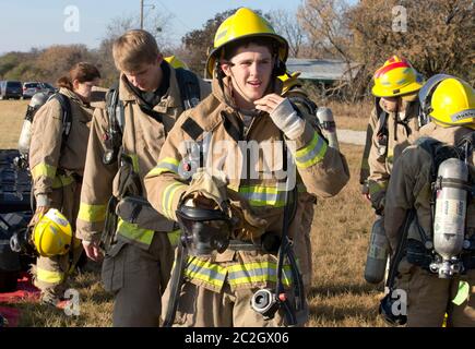 Austin Texas, USA, Februar 4 2014: Schüler der LBJ High School Fire Training Academy mit Wahlausrüstung bereiten sich auf eine Trainingsübung vor. Studierende, die das zweijährige Programm absolvieren, sind für die EMT-Zertifizierung als Notarzt qualifiziert und verfügen über fortgeschrittene Fähigkeiten zur Brandbekämpfung. ©Bob Daemmrich Stockfoto