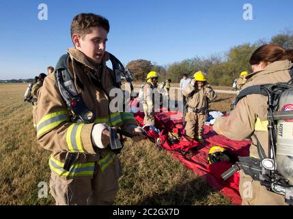 Austin Texas, USA, Februar 4 2014: Schüler der LBJ High School Fire Training Academy mit Wahlausrüstung bereiten sich auf eine Trainingsübung vor. Studierende, die das zweijährige Programm absolvieren, sind für die EMT-Zertifizierung als Notarzt qualifiziert und verfügen über fortgeschrittene Fähigkeiten zur Brandbekämpfung. ©Bob Daemmrich Stockfoto