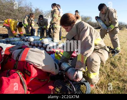 Austin Texas, USA, Februar 4 2014: Schüler der LBJ High School Fire Training Academy tragen Wahlausrüstung und bereiten sich auf eine Trainingsübung mit Lufttanks vor. Studierende, die das zweijährige Programm absolvieren, sind für die EMT-Zertifizierung als Notarzt qualifiziert und verfügen über fortgeschrittene Fähigkeiten zur Brandbekämpfung. ©Bob Daemmrich Stockfoto