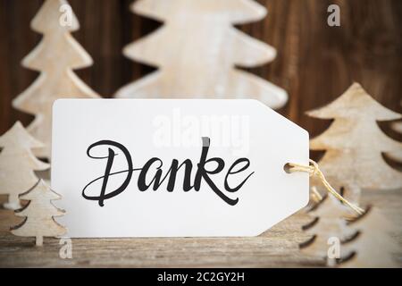 Label Mit Deutschem Text Danke Bedeutet Danke. Weißer Holz-Weihnachtsbaum Als Dekoration. Brauner Holzhintergrund Stockfoto