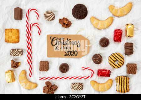 Ein braunes Label mit englischer Kalligraphie Frohe Weihnachten und EIN Happy 2020. Christmas Candy Collection Mit Hausgemachten Cookies. Stockfoto