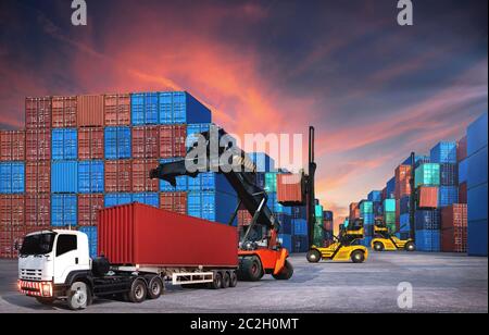 Am Hafen arbeitet der Gabelstapler, um den Container-Kasten im Stapelhof hochzuheben Stockfoto