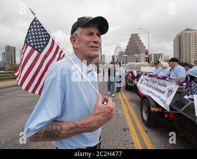 Austin Texas, USA, November 11 2015: Der Veteran Joe Barger aus Austin hält eine kleine amerikanische Flagge, während die Teilnehmer sich auf die jährliche Parade zum Veterans Day auf der Congress Avenue vorbereiten. ©Bob Daemmrich Stockfoto