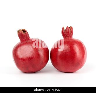 Zwei reife rote Granatäpfel in einer Schale auf einem weißen Hintergrund, in der Nähe Stockfoto