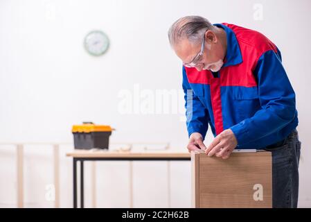 Alte Tischler, die in Innenräumen an Möbeln arbeiten Stockfoto