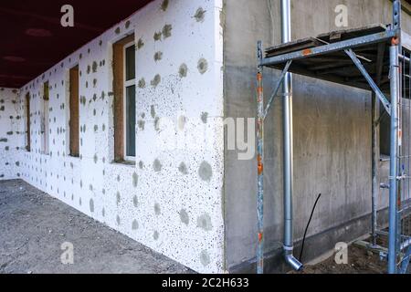 Die Fassade des Hauses ist vor der Oberflächenbehandlung mit Wärmedämmplatten bedeckt Stockfoto