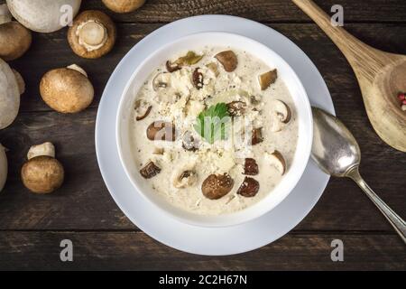 Pilzsuppe, Schuß von der Oberseite mit Zutaten auf einem dunklen Holzmöbeln im Landhausstil Hintergrund Stockfoto