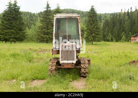 Der alte Traktor auf dem Feld im Dorf im Sommer Stockfoto