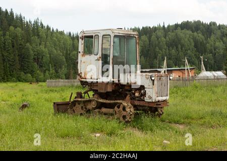 Der alte Traktor auf dem Feld im Dorf im Sommer Stockfoto