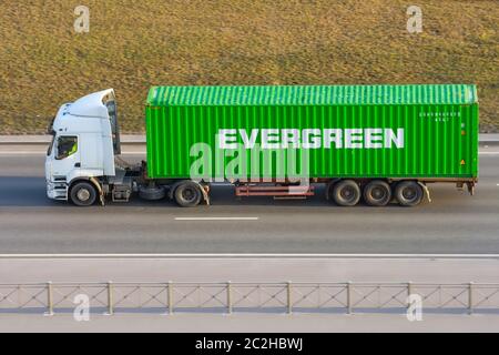 LKW mit Anhänger und grünen Container-Unternehmen Evergreen auf Stadtautobahn. Russland, Sankt Petersburg. April 2020 08 Stockfoto