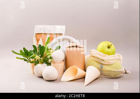 Bälle zum Waschen und Street Fast Food Pappbecher, Teller und Behälter. Umweltfreundliche Lebensmittelverpackungen und Öko-Beutel aus Baumwolle auf grauem Hintergrund mit Kopierplatz. Natur- und Recyclingkonzept Stockfoto