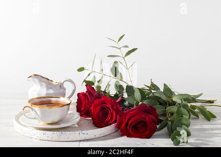 Ein Hochzeitsstrauß aus drei Rosen und verschiedenen Eukalyptussorten in einem Glaskrug auf der Fensterbank. Leerzeichen für Text Stockfoto
