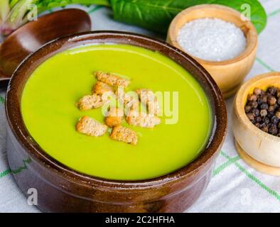 Spinat-Suppe serviert auf Holzbrett Stockfoto