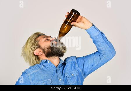 Betrunken Hipster männlichen Handwerk abgefülltes Bier. Glücklicher Mann halten volle Glasflasche in der Hand. Männlich hält Flasche Bier. Hipster Rest in Pub. Sportliebhaber aufmuntern. Reifer Mann hält eine Glasflasche Bier. Stockfoto