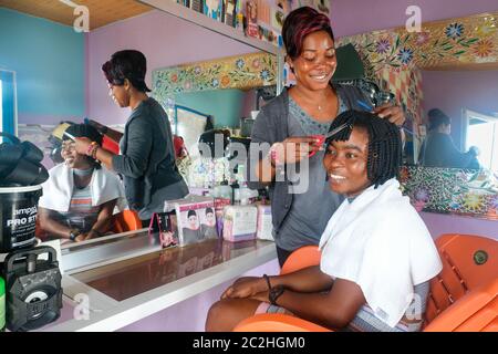 Friseurin Naomi Boateng (35) betreut einen Kunden in ihrem Friseursalon in Tikobo in Ghana, Afrika. Stockfoto