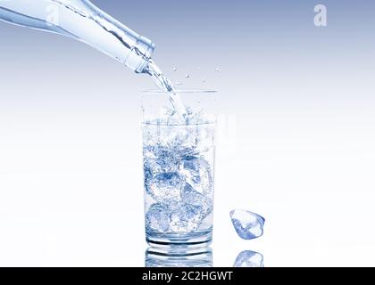 A water glass full of ice cubes is filled with fresh water Stockfoto