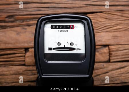 Nahaufnahme einer Kilowattstunde Strom Zähler auf hölzernen Schreibtisch Stockfoto