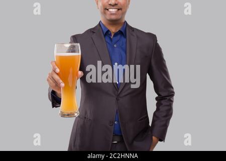 Geschäftsmann Zeigt Bierglas. Indischer Geschäftsmann mit Bier in der Hand Nahaufnahme Stockfoto