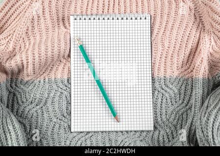 Notebook auf Textur Pullover mit leeren Raum für Text. Die Aussicht von oben. Flach Stockfoto