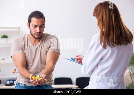 Männlicher Diabetiker, der einen jungen Arzt besucht Stockfoto