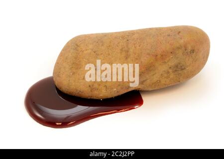 Ein isolierter Fels, der blutet, um dem Sprichwort einen Sinn zu geben, wie Blut aus einem Stein zu bekommen. Stockfoto