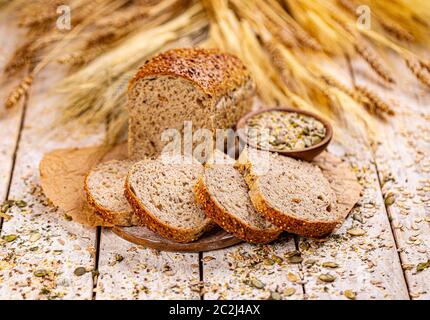 Brot mit verschiedenen Samen, Kürbis, Mohn, Flachs, Sonnenblumen-, Sesam, auf hölzernen Hintergrund Stockfoto