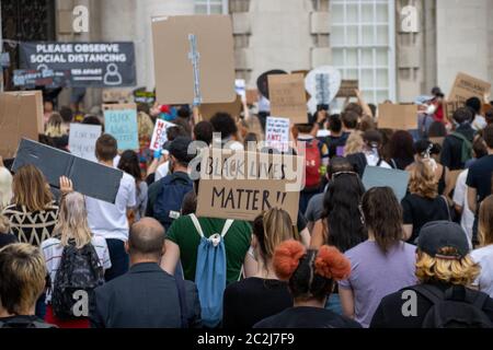 Leeds UK, 14. Juni 2020: Black Lives Matter Demonstranten im Stadtzentrum von Leeds protestieren gegen Black Lives mit einer jungen Frau, die ein Schild hochhält Stockfoto