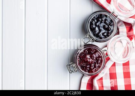 Heidelbeere und Himbeere Marmelade im Glas auf weißer Tisch. Ansicht von oben. Stockfoto