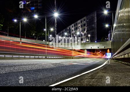 Tunnelöffnung in der Stadt mit Autowegen umgeben von Asphalt und Beton mit modernen Gebäuden Stockfoto