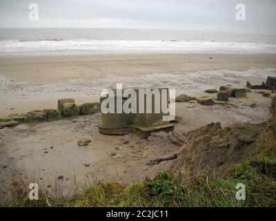 Zweiter Betonkasten im Weltkrieg an der Ostküste von Yorkshire, England, Großbritannien. Mit Beton versiegelte Schlupflöcher. Umgeben von einem Sandstrand wi Stockfoto