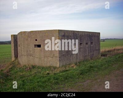 Zweiter Betonkasten im Weltkrieg an der Ostküste von Yorkshire, England. Hinterer Eingang und Schlupflöcher sichtbar. Umgeben von Gras. Blauer Himmel mit Weiß Stockfoto