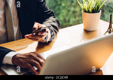 Geschäftsmann mit Technologie, Smart Phone mit Laptop auf dem Schreibtisch Büro Stockfoto