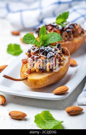 Birnen gebacken mit Rosinen, Nüssen, Honig und Minze. Stockfoto